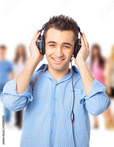 Portrait of a happy young guy listning to music against