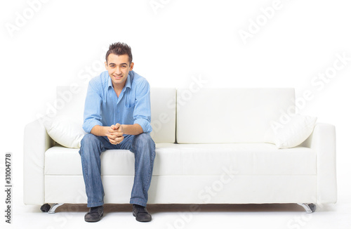 Portrait of the young man in white on sofa