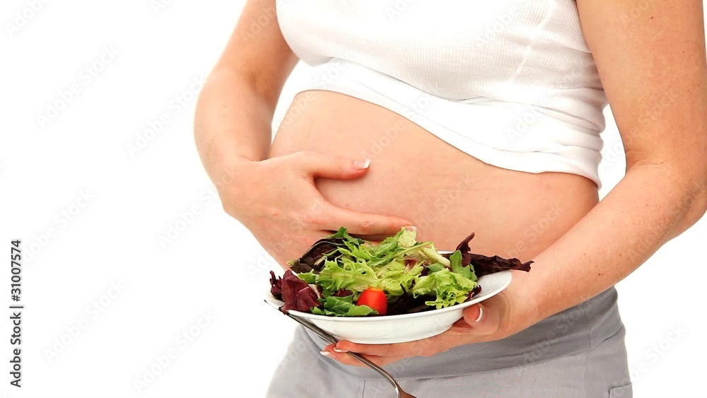 Expecting woman holding a salad Expecting woman holding a salad