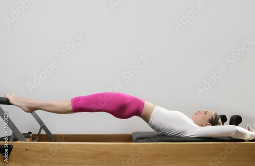 gym woman pilates stretching sport in reformer bed photo