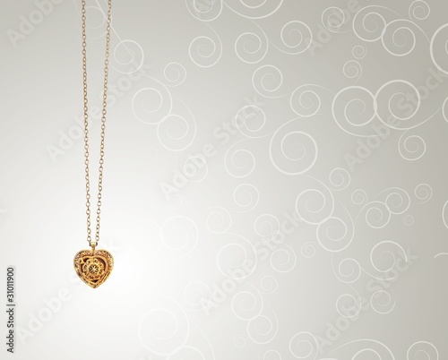 gold heart-shaped pendant on curls background