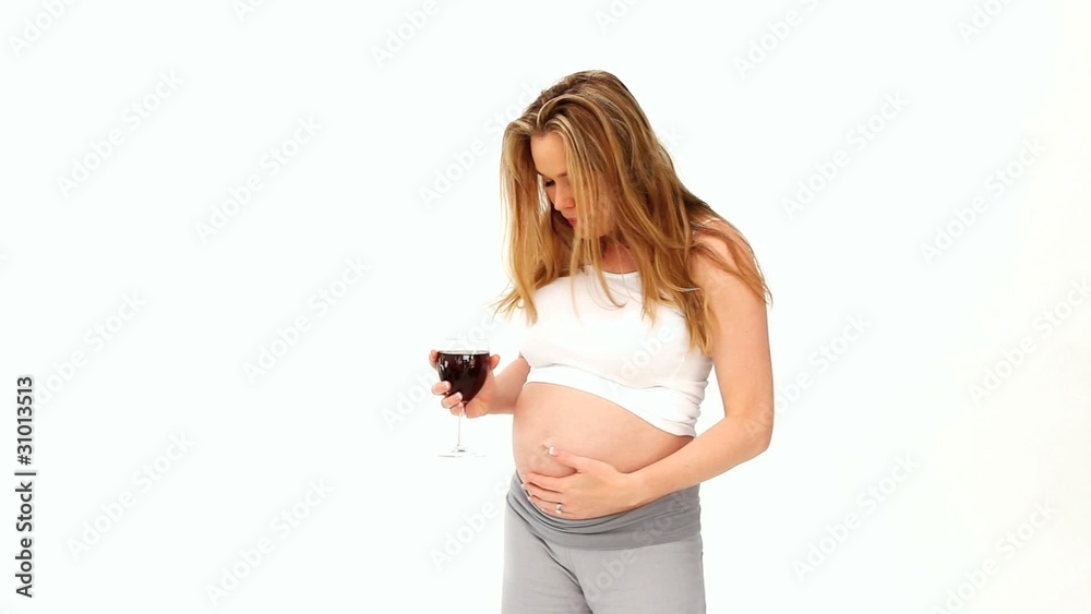 Pregnant woman drinking a glass of red wine Pregnant woman drinking a glass of red wine