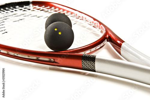Close up of a red and silver squash racket and ball