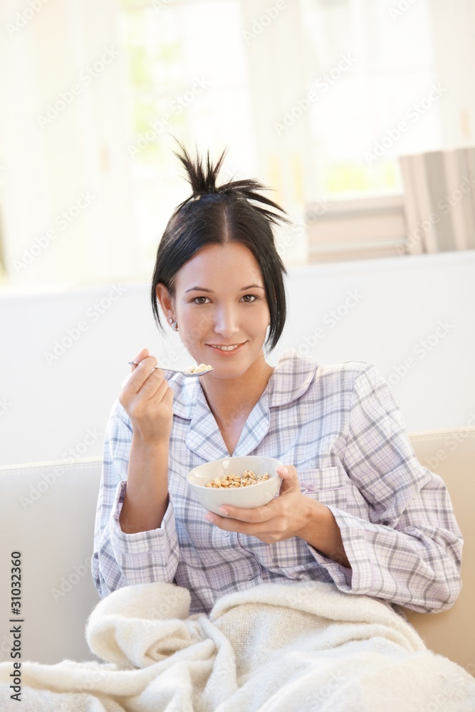 Portrait of woman having cereal on sofa Portrait of woman having cereal on sofa