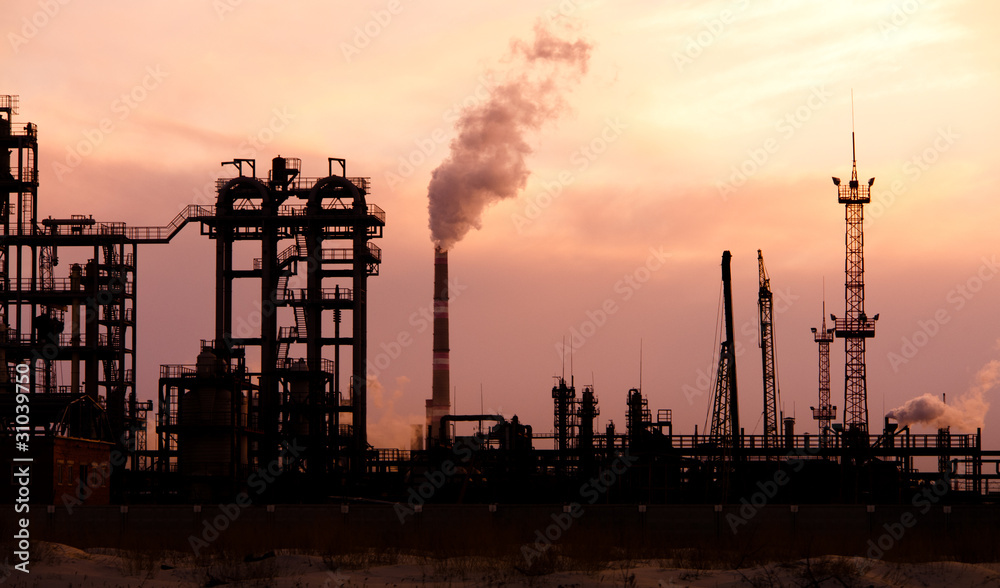 Oil refinery at sunset. Enviroment pollution.