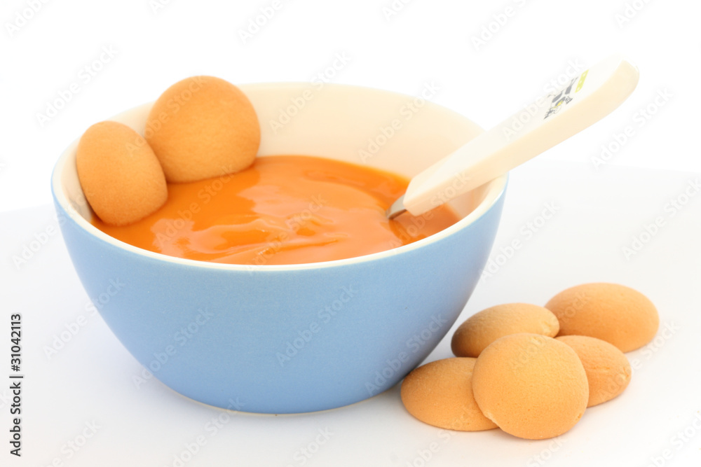 Red bowl with children fruit pap / mush with sponge-biscuits Red bowl with children fruit pap / mush with sponge-biscuits