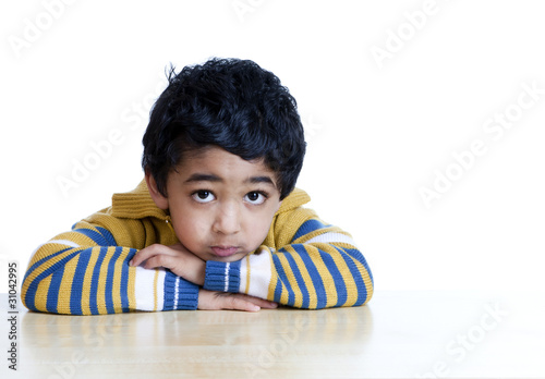 Fotografie Portrait of a Serious Toddler with face resting on folded hands