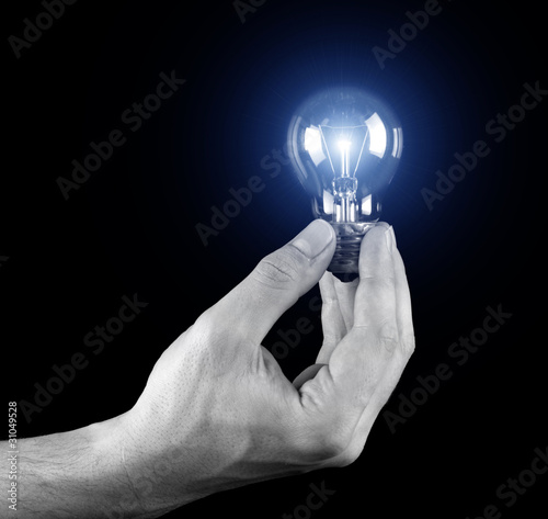 Hand holding light bulb isolated on black
