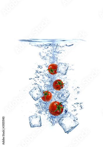 Ice cubes with cherry tomatoes splashing