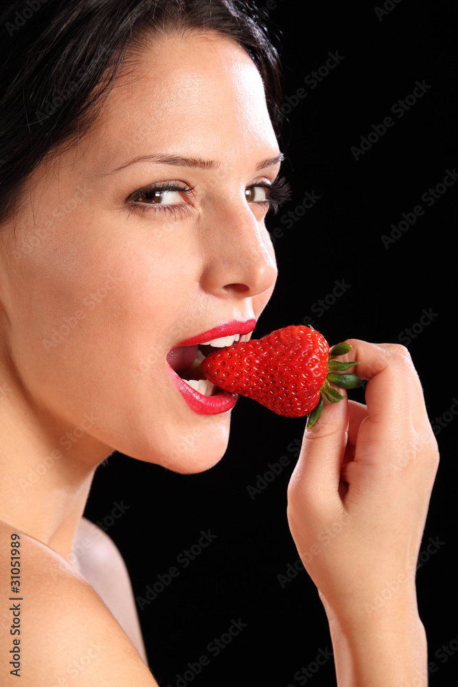 Sexy look by woman eating fresh strawberry fruit Sexy look by woman eating fresh strawberry fruit