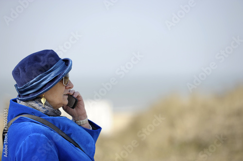 senior woman in blue with cell phone