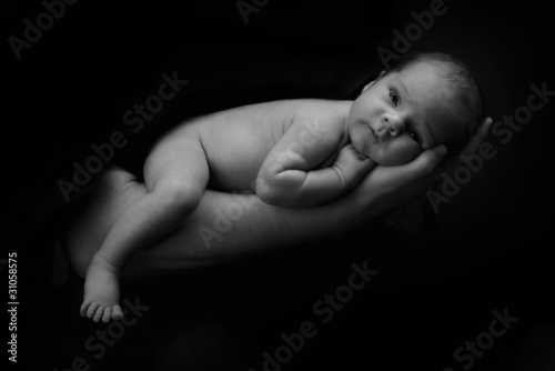 Newborn baby on the father's hand, b/w