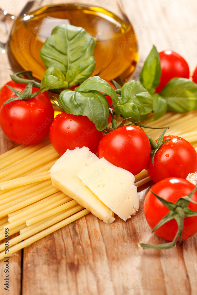 pasta, olive oil and tomatoes on the wood background