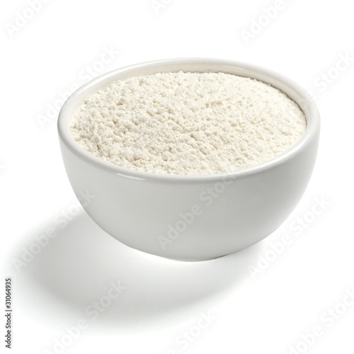 Wheat flour in a plate on white background