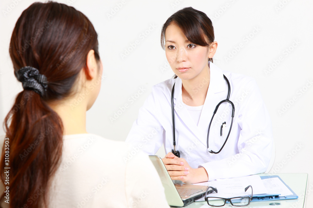 japanese female doctor talks by serious expression with patient japanese female doctor talks by serious expression with patient