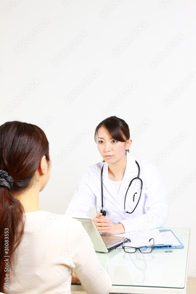 japanese female doctor talks by serious expression with patient japanese female doctor talks by serious expression with patient