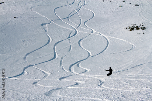 Snowborder leaving new track on snow powder