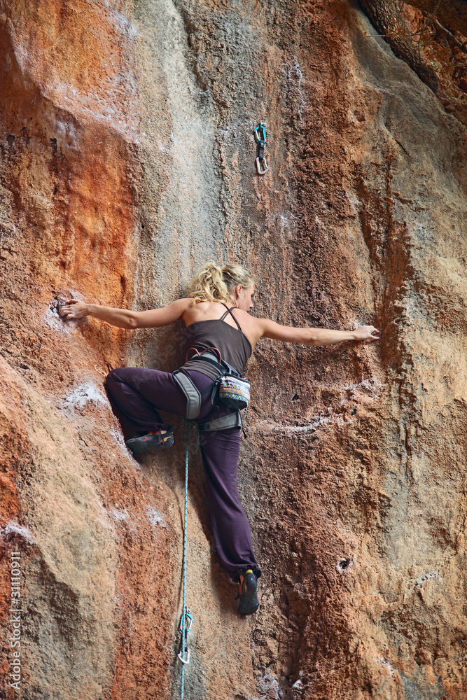 Female rock climber battling her way up Female rock climber battling her way up
