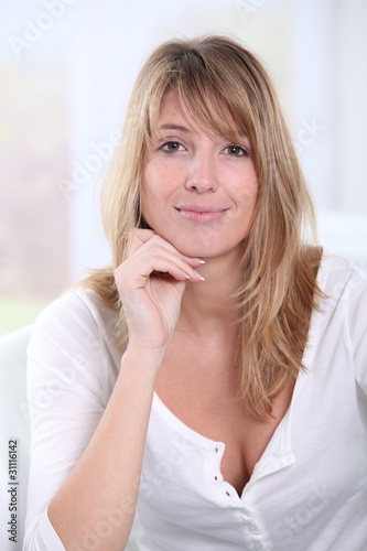 Portrait of beautiful blond woman sitting in sofa