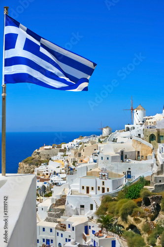 Beautiful Oia windmill with national flag of Greece