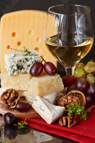 Assortment of cheese, red and green grapes and nuts.