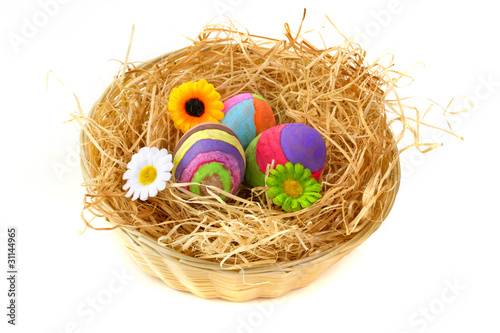 Colorful Easter eggs on hay in the basket