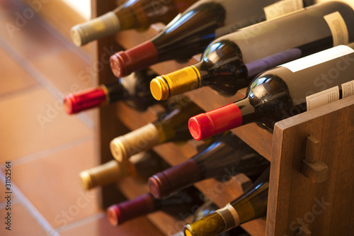 Red and white wine bottles stacked on wooden racks