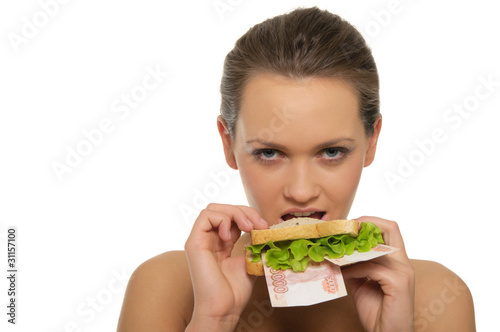 Woman biting a sandwich out of money and lettuce