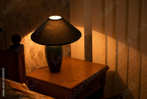Cozy lamp on a night stand (shining in the darkness)