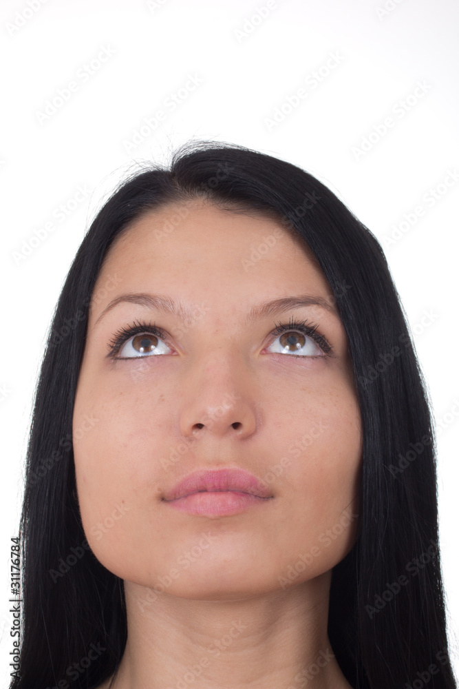 The girl looks upwards on a white background