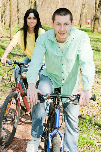 young man and woman on bicycle outdoors happiness