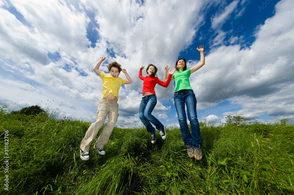 Active family - mother and kids jumping outdoor Active family - mother and kids jumping outdoor