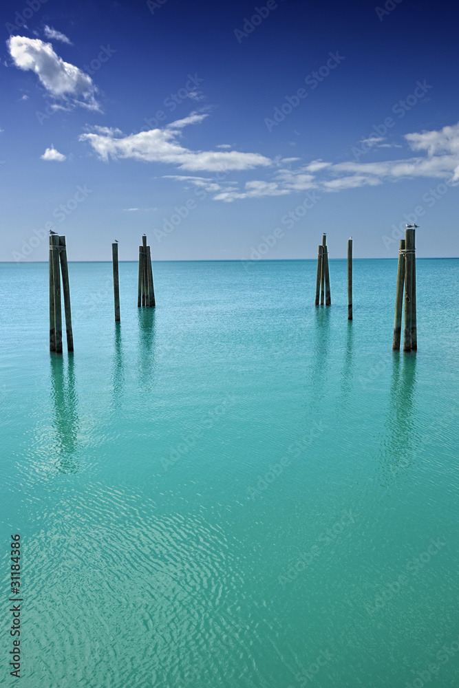 Mooring posts leading in turquoise sea in Governor's Harbour