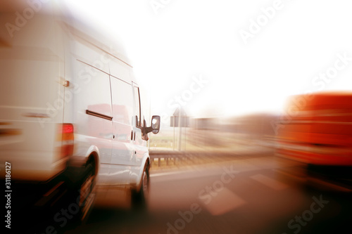 Fototapeta Trucks, delivery vans on freeway. Logistics