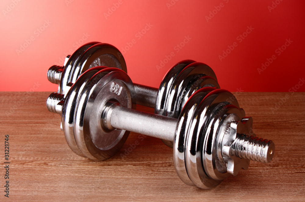 Dumbbell on red background Dumbbell on red background