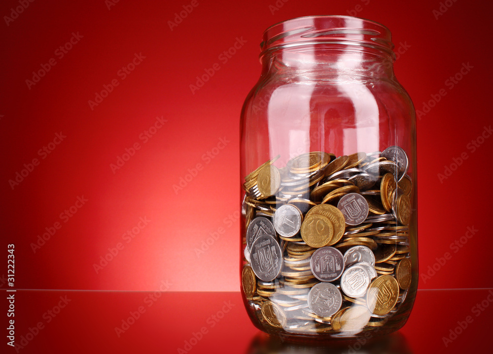 coins in money jar on red background. Ukrainian coins coins in money jar on red background. Ukrainian coins