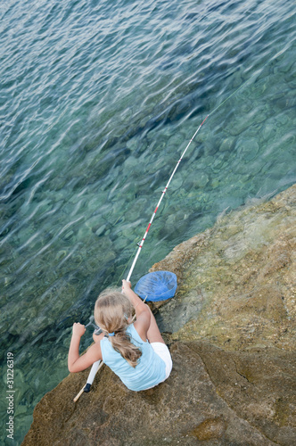 Little girl fishing at the beach