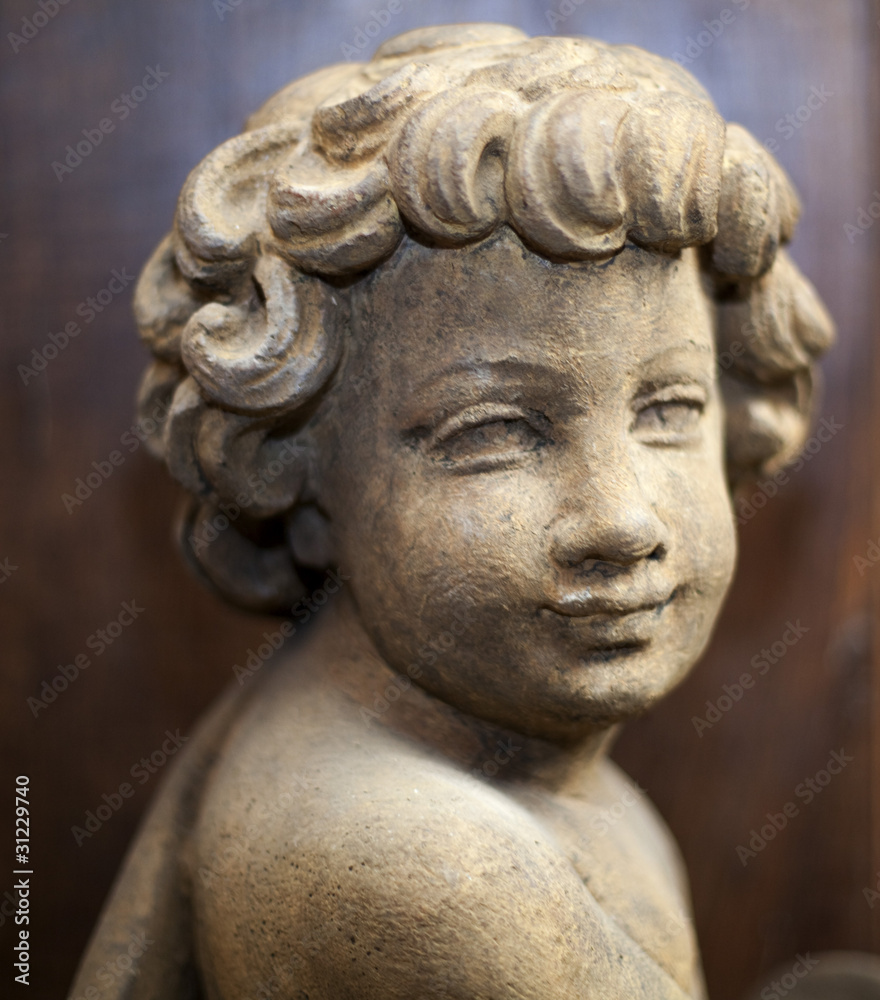 statue de pierre d'enfant souriant