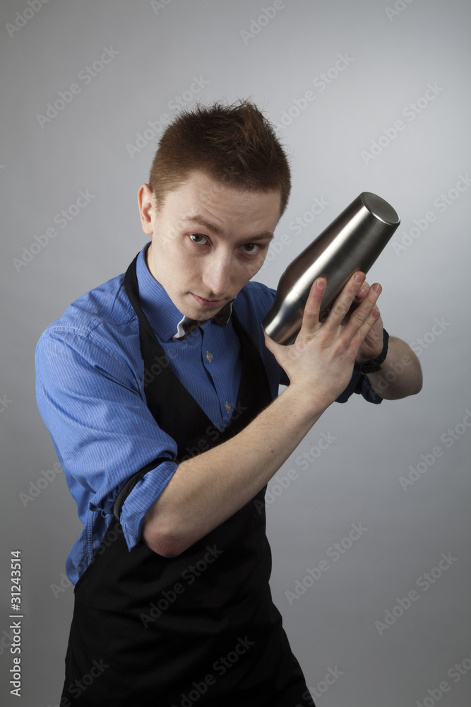 Young barman works with a shaker