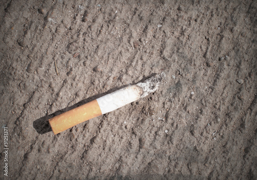 cigarette butt on the dirty concrete surface