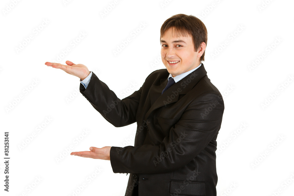 Friendly businessman presenting something on empty hands Friendly businessman presenting something on empty hands