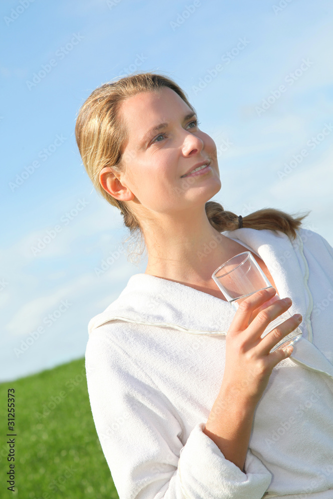 Woman drinking natural water in green field Woman drinking natural water in green field