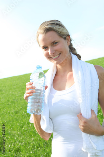 Woman drinking water from water during fitness activity