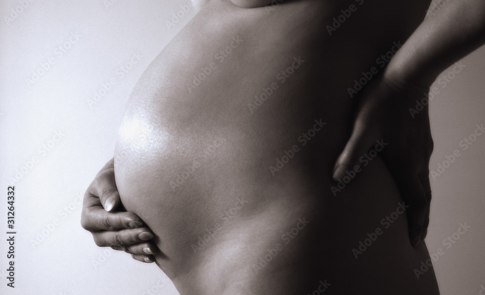 Nude Pregnant Woman With Hand On Belly