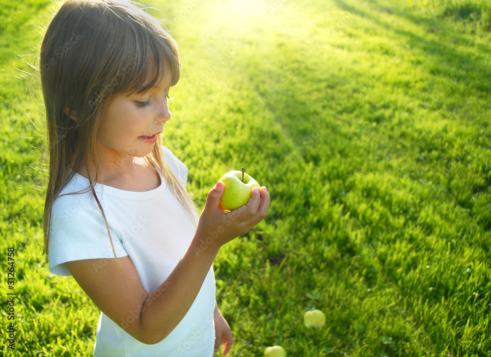 Little girl with apple, sunbeam in background Little girl with apple, sunbeam in background