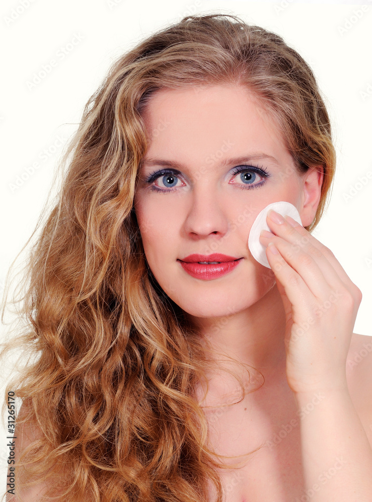 Beautiful young woman cleaning face with cotton pad Beautiful young woman cleaning face with cotton pad