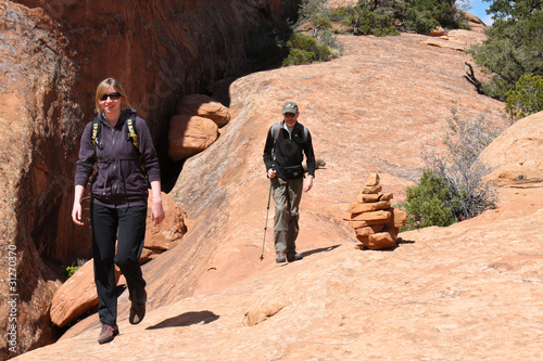 Hikers on a sand stone slab - Arches NP
