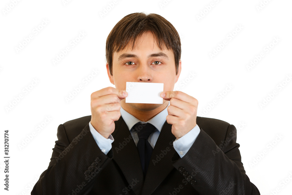 Businessman holding blank business card in front of mouth Businessman holding blank business card in front of mouth