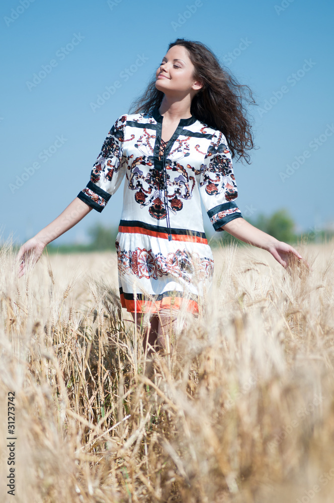 Beautiful woman walk in wheat field on sunny summer day. Beautiful woman walk in wheat field on sunny summer day.