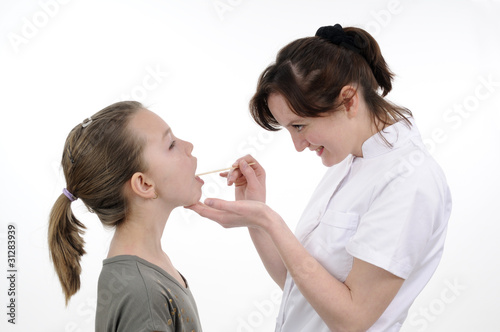 young doctor examining teenager mouth